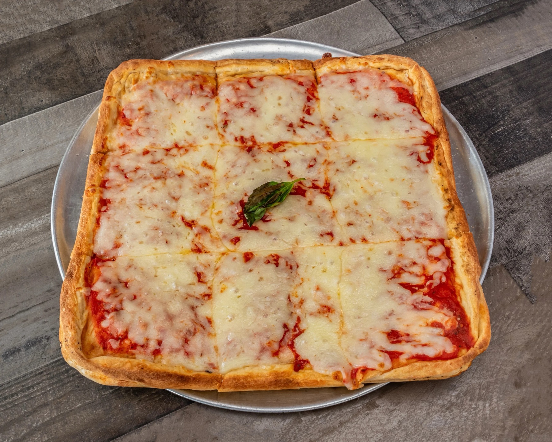 Mister P's fresh square cheese pizza, cut and ready to serve
